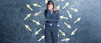 Femme en tailleur qui se cache le visage avec sa main. Débordée et manque de confiance