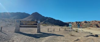 a sign that says private parking lot in front of a mountain