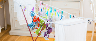 a laundry basket with cloth diapers hanging on a clothes rack