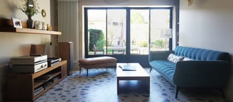 Salon avec baie vitrée, sol Terrazo, mur peint, mobilier hifi , décoration chic, salon cuir et tissu