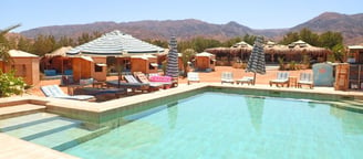 Beach with pool and lounge chairs and umbrellas