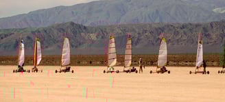 a group of people are sailing on the beach