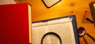 Papiers de révisions éparpillés sur un bureau, livres de médecine ou d’anatomie ouverts, vu du dessus, éclairé d’une lumière 