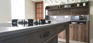 Cuisine bois teinté, meubles beige anti trace de doigts. Ilot central en bois avec dessus pierre.