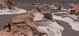 a person standing on a rock formation in the desert