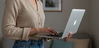 female business coach typing on Apple laptop
