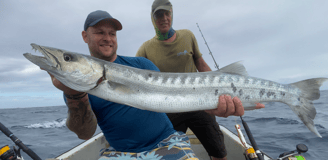 An angler holding a freshly caught Barracuda during the peak Zanzibar fishing season