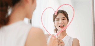 Femme qui dessine un coeur sur son miroir