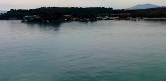 Foto tirada do convés mostrando a cidade de Vólos ao amanhecer, na chegada de navio.
