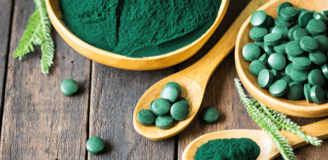 Un bol de spiruline en poudre et un autre bol avec des comprimés de spiruline