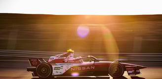 a man driving a Formula E race car on a track