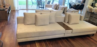 Sofa feito sob medida em linho branco e apoio de braço no meio de madeira