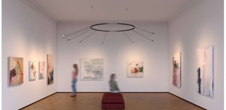 Iluminación técnica de galería con focos orientables sobre obras de arte