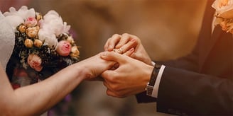 a bride and groom holding hands in a wedding ceremony