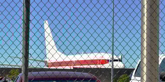 a plane is parked in front of a fenced in area