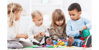 4 young children playing with toys on the floor