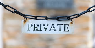 a private sign hanging from a chain link