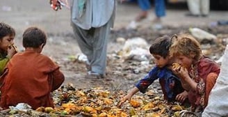 a group of children eating fruit from a pile of fruit