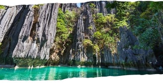 Foto de fundo da página em passeio de barco por Palawan, Filipinas, entre águas cristalinas e formações rochosas.