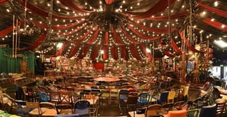 a circus tent with a circus tent and lots of chairs