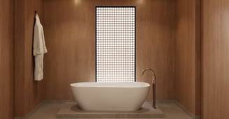Freestanding bathtub in wood-paneled minimalist bathroom with soft lighting and grid-screen window.