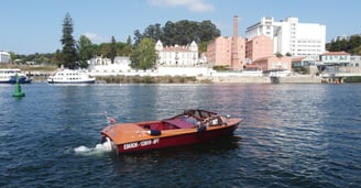 Couple enjoying private vintage wooden boat tour on the Douro River in Porto, Portugal