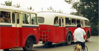 a man riding a bicycle with a bicycle in front of a bus