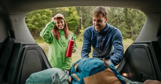 Couple packing their bags in the trunk of their car ready to go hiking for the day