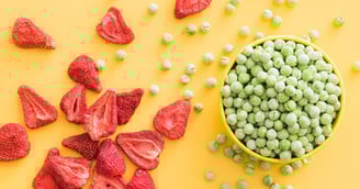 thrive life freeze dried strawberries and green peas on a vibrant yellow background