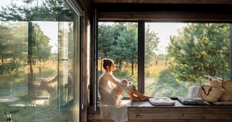 Femme paisible dans son salon en bois, évoquant le feng shui