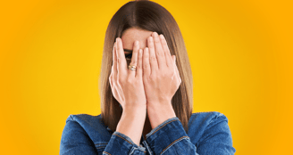 Femme qui se cache le visage avec ses mains. Manque de confiance en soi.
