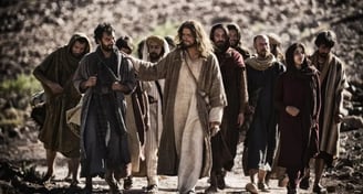 jesus walking down a dirt road with a group of people