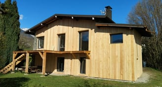a house with a wooden siding and a staircase leading to a deck