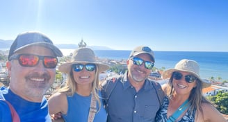 a group of people standing around a man in a hat