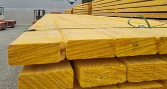 a stack of wooden planks in a warehouse, bois d'ossature, ossature bois, charpente, maison en bois,