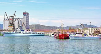 Vista da cidade de Vólos a partir do píer, com barcos ao fundo.