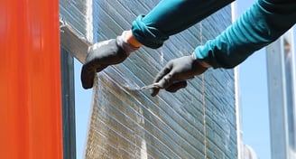Person installing insulation on metal building