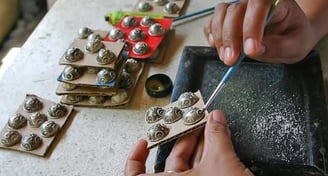 a person is using a pair of scissors to cut a button
