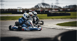 Piloti in gara durante una competizione di karting, esempio di attività motorsport di noline