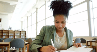 A woman writing on her free Revive after 40 Perimenopause Survival Checklist