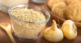 a bowl of maca powder and maca root