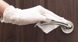 photo of hand with white glove cleaning door handle