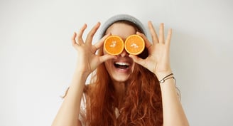 Mujer con rodajas de cítrico en sus ojos