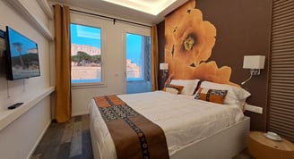 a bedroom with a large bed and a television for vacation with view of Cagliari
