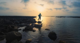 a man standing on rocks in the water