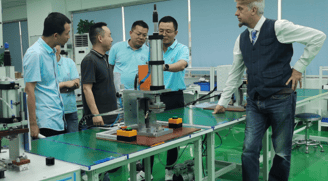 a man standing in a factory with a machine
