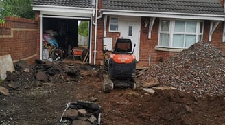 mini digger and wheel barrow outside a house in west brom