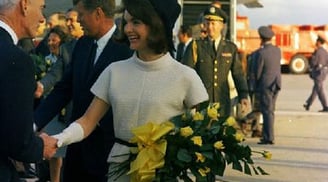 a man and woman shaking hands in front of a plane