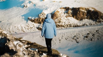 Une femme qui marche avec une veste bleue de dos 