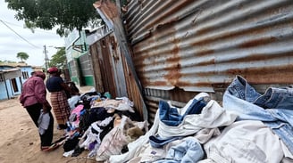 a group of people standing around a pile of clothes Xipamanine Maputo